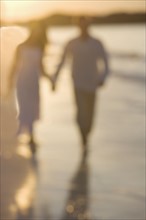Couple strolling on a beach.