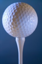 Closeup of golf ball on tee.