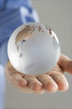 Closeup of glass globe in palm.