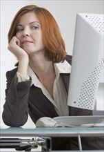 Businesswoman looking askance at her computer.