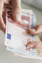 Closeup of hands with European money.