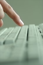 Profile of finger and computer keyboard.