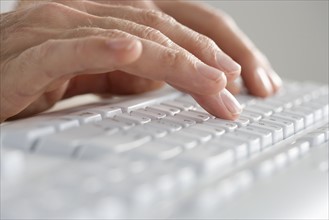 Closeup of hands on computer keyboard.