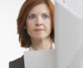 Woman at computer with paper.