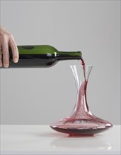 Red wine pouring into carafe.