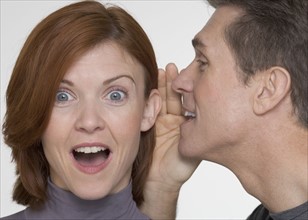 Man telling woman surprising secret.