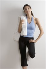 Woman in workout clothes with towel.
