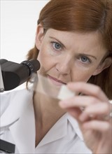 Woman with microscope and slide.