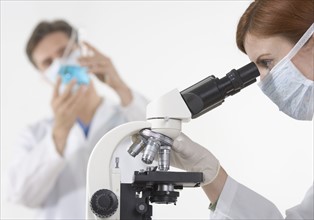Scientists in laboratory with microscope.