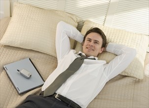 Closeup of businessman resting on bed.