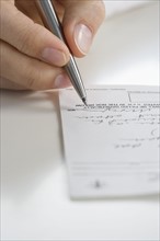 Closeup of hand writing prescription.