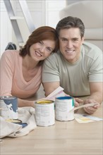 Smiling couple picking out paint colors.