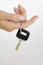 Female hand holding car key.