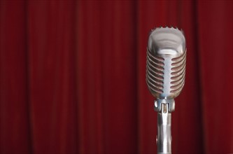 Old fashioned microphone with red curtain.