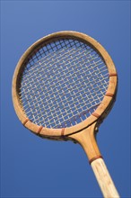Closeup of an antique tennis racquet.