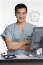 Male healthcare worker standing at desk.