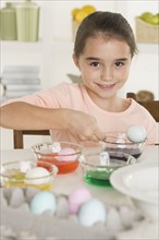 Girl coloring Easter eggs.