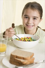 Young girl eating breakfast cereal.
