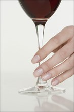 Female hand holding glass of wine.