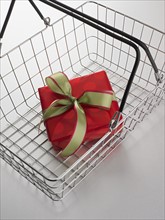 Still life of shopping basket with gift inside.