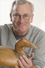 Man holding handmade wooden duck.