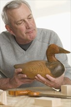 Man holding handmade wooden duck.