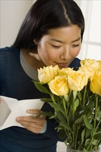 Woman smelling bouquet of roses.