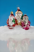 Three Santa Claus Christmas ornanaments.