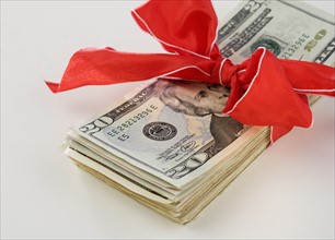 A stack of money with a bow.