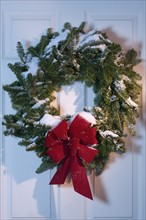 Still life of Christmas wreath on door.