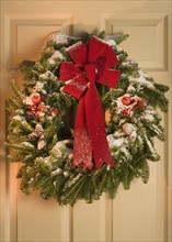 Still life of Christmas wreath on door.