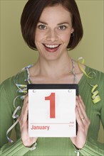 Woman holding calendar on first day of the year.