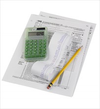 Still life of tax forms, pencil, calculator.