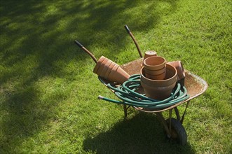 Still life of wheelbarrow and gardening tools.