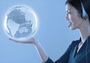 Woman with headset holding a globe.