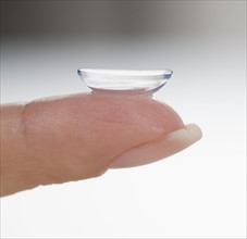Closeup of finger with contact lens.