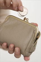 Woman putting change in coin purse.