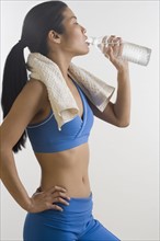 Woman drinking bottled water after workout.