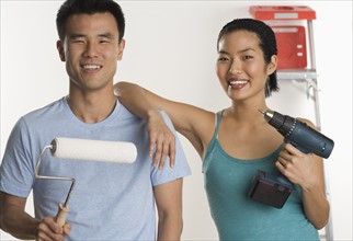 Portrait of couple doing home repairs.