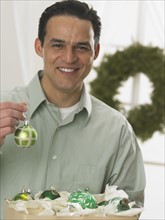 Portrait of man holding Christmas ornament.