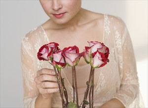 Close up of woman arranging stemmed roses.