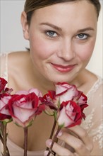 Close up of woman with stemmed roses.
