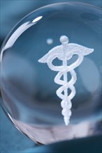 Close up of clear ball with Caduceus symbol in it.