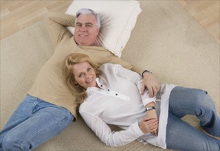 Senior couple lying on floor.
