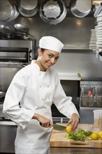Female chef in restaurant kitchen.