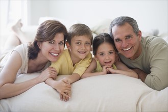 Family lying on bed.