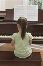 Young girl playing piano.
