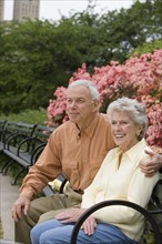 Senior couple sitting on park bench.