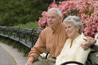 Senior couple sitting on park bench.