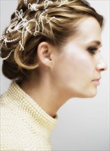 Profile of woman with small pearls in hair.